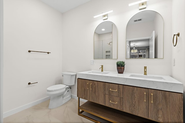 bathroom featuring toilet, vanity, and walk in shower