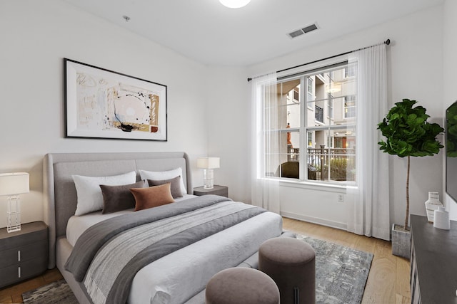 bedroom with light wood-type flooring and multiple windows