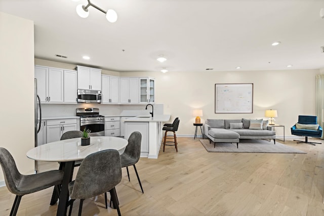 dining room with light hardwood / wood-style flooring and sink