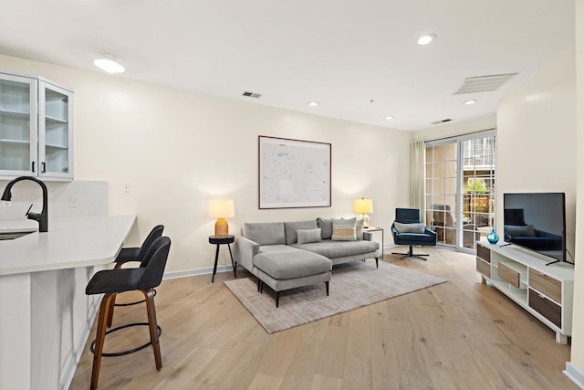 living room featuring light hardwood / wood-style floors and sink