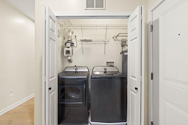 washroom with light wood-type flooring and washing machine and clothes dryer