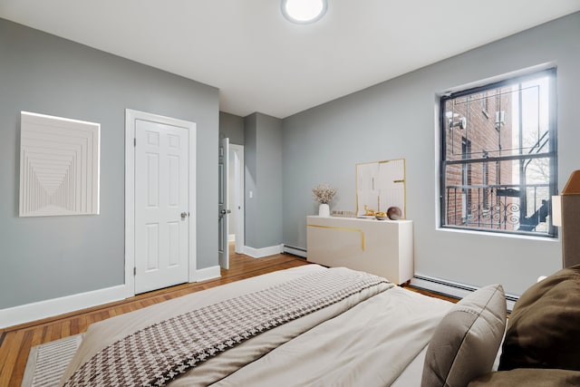 bedroom featuring hardwood / wood-style floors and a baseboard radiator