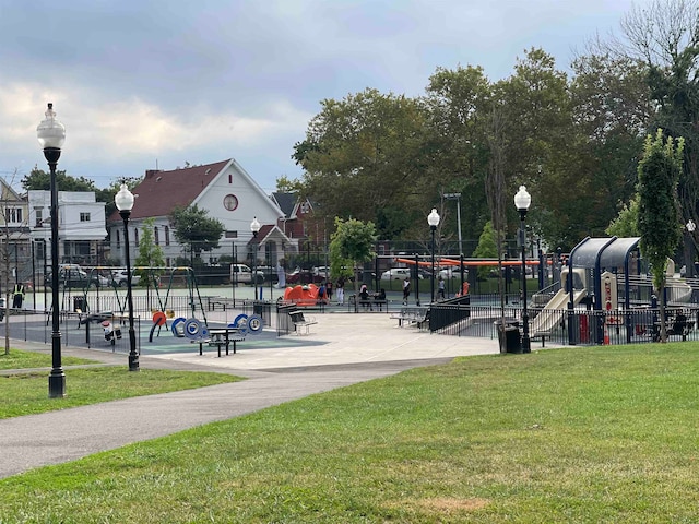 view of home's community featuring a playground and a yard