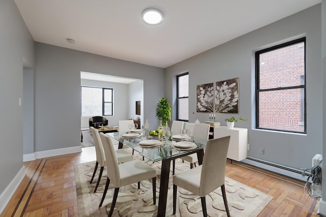 dining room featuring light parquet flooring and a baseboard heating unit