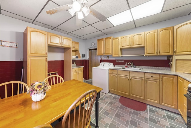 kitchen with a paneled ceiling, washer / clothes dryer, open shelves, and a sink