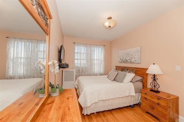 bedroom featuring radiator and wood-type flooring