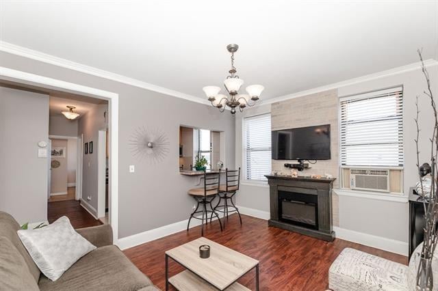 living room featuring ornamental molding, dark hardwood / wood-style floors, a large fireplace, cooling unit, and a notable chandelier