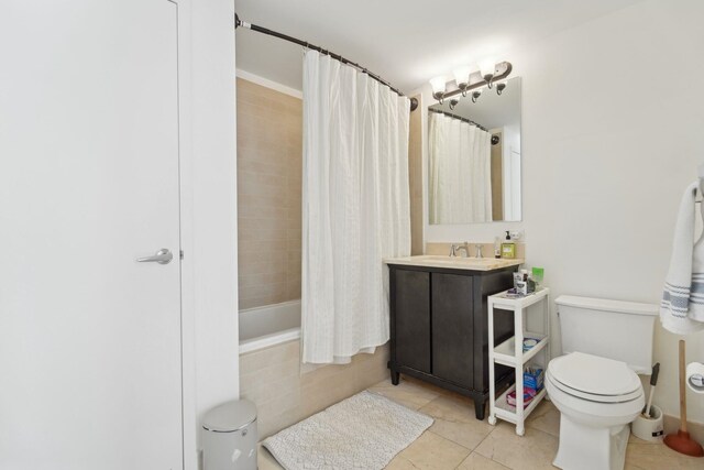 bathroom with tiled shower / bath combo, tile patterned floors, vanity, and toilet