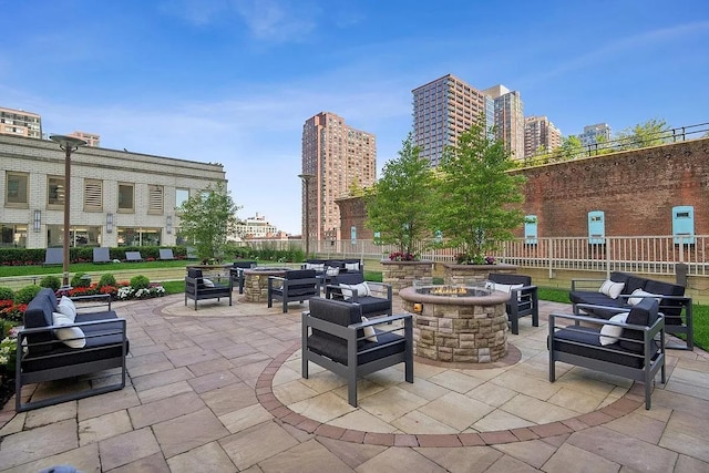 view of patio featuring a view of city and an outdoor living space with a fire pit