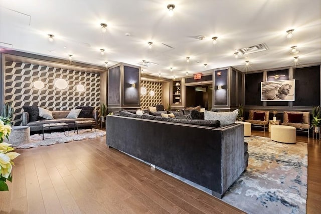 living area featuring visible vents, hardwood / wood-style flooring, and wallpapered walls