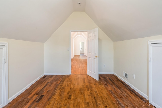 bonus room with vaulted ceiling and dark hardwood / wood-style floors