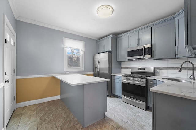 kitchen featuring stainless steel appliances, a sink, gray cabinets, tasteful backsplash, and crown molding