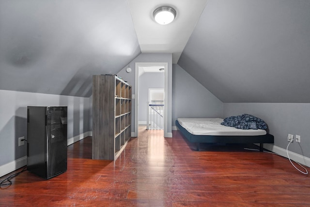 bedroom with lofted ceiling, baseboards, and wood finished floors