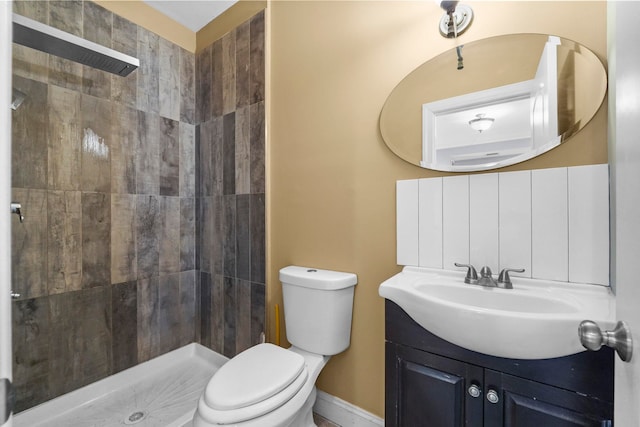 full bathroom featuring a stall shower, baseboards, vanity, and toilet