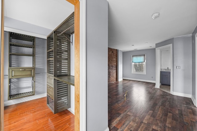 walk in closet with wood finished floors