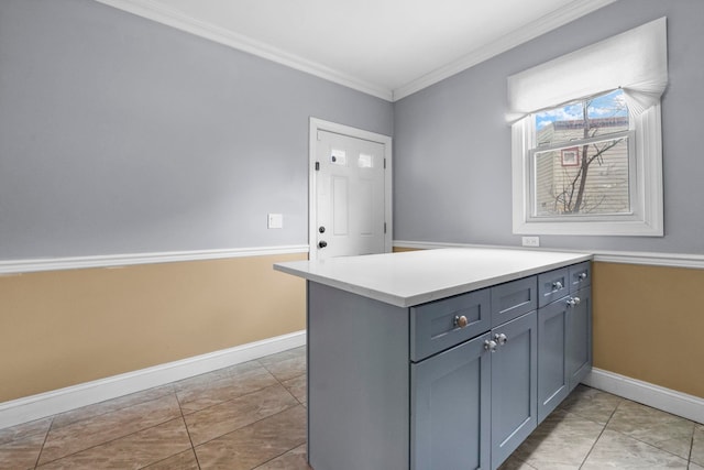 kitchen with baseboards, light countertops, crown molding, and light tile patterned flooring