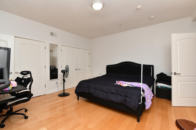 bedroom featuring light wood finished floors and visible vents