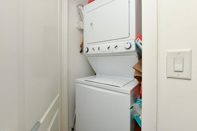 clothes washing area featuring stacked washer / drying machine and laundry area