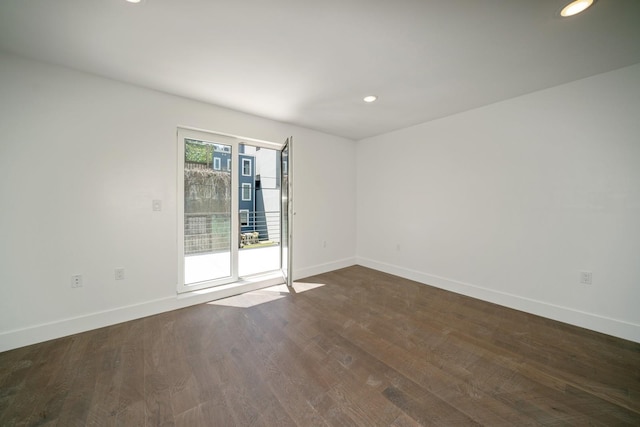 empty room featuring recessed lighting, dark wood finished floors, and baseboards