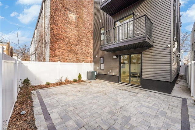 view of patio featuring a balcony, a fenced backyard, and central AC