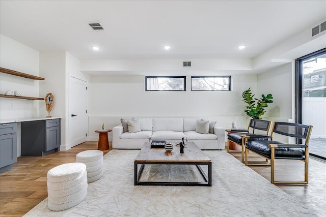 living room featuring recessed lighting, visible vents, and light wood-type flooring