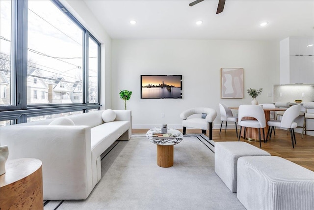 living room featuring ceiling fan, recessed lighting, light wood-type flooring, and baseboards