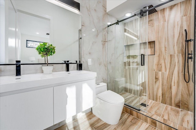 full bath with a marble finish shower, toilet, and vanity