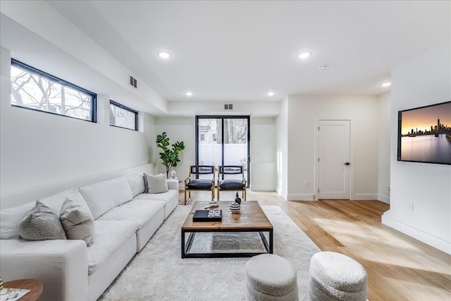 living area with recessed lighting, visible vents, baseboards, and light wood-style flooring