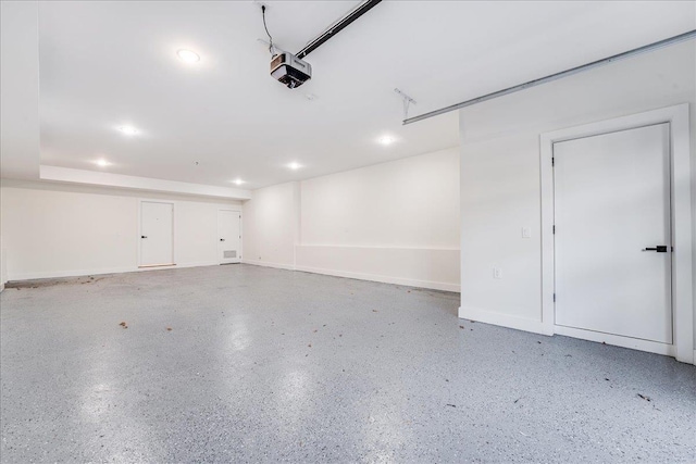 garage featuring recessed lighting, a garage door opener, and baseboards