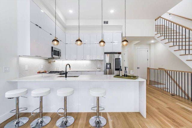 kitchen with white cabinetry, appliances with stainless steel finishes, modern cabinets, and a sink