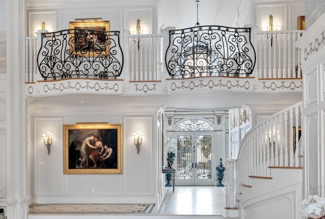 entryway featuring ornamental molding, french doors, and a high ceiling