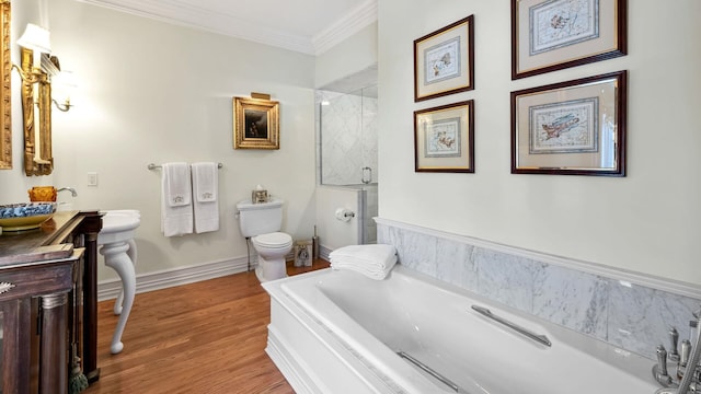 bathroom with hardwood / wood-style floors, a tub, toilet, and ornamental molding