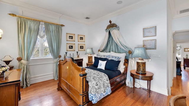 bedroom with hardwood / wood-style floors and ornamental molding