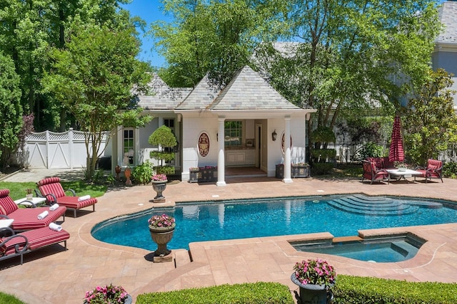 view of swimming pool featuring a patio and an in ground hot tub