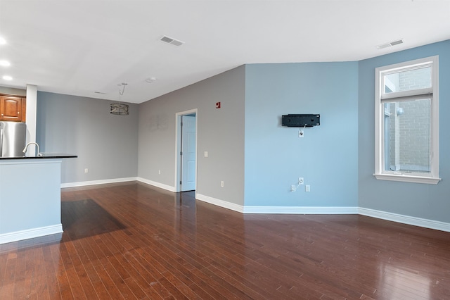 unfurnished living room featuring sink and dark hardwood / wood-style floors