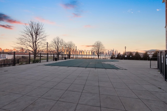 pool at dusk featuring a patio