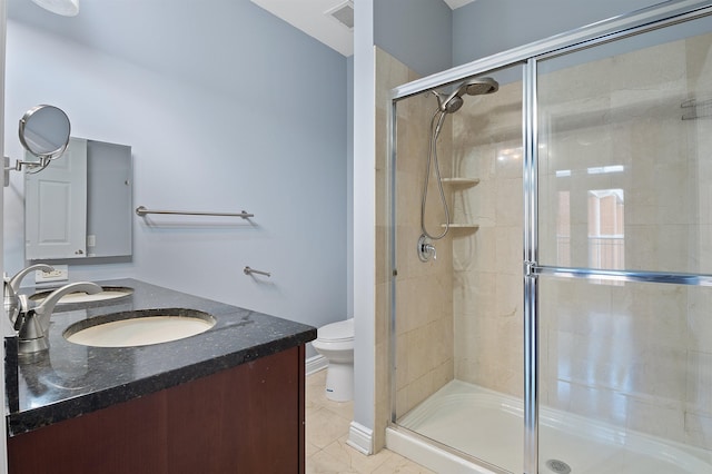 bathroom featuring tile patterned floors, an enclosed shower, vanity, and toilet