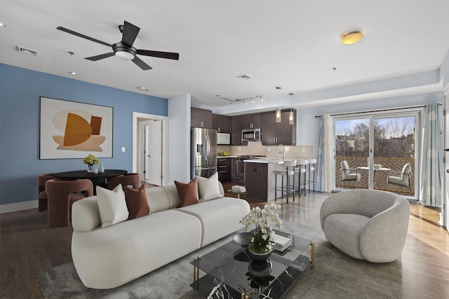 living room with rail lighting, baseboards, visible vents, and dark wood-type flooring