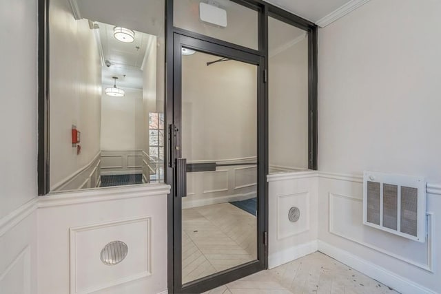 bathroom featuring crown molding, a decorative wall, and visible vents