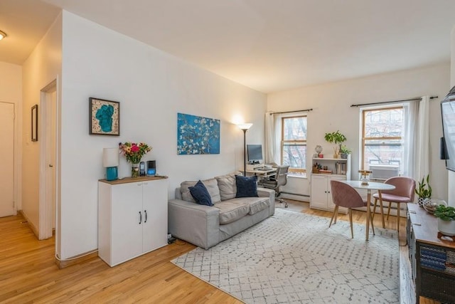 living area featuring a baseboard heating unit and light wood-type flooring