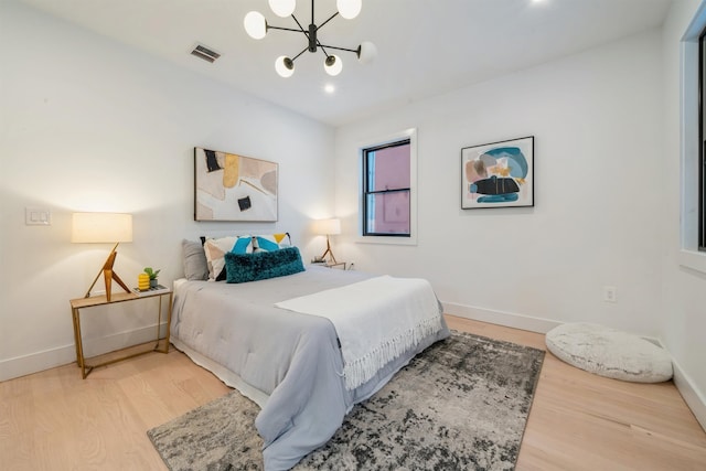 bedroom featuring wood-type flooring and a notable chandelier