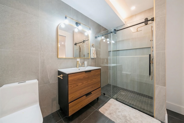 bathroom with a shower with door, tile walls, vanity, and tile patterned flooring