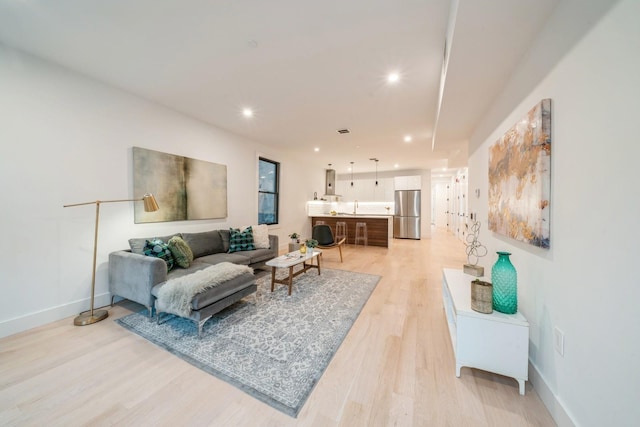 living room with sink and light hardwood / wood-style flooring