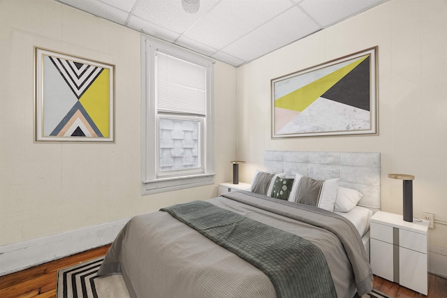 bedroom featuring a paneled ceiling and wood-type flooring