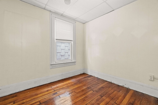 unfurnished room featuring hardwood / wood-style flooring and a drop ceiling