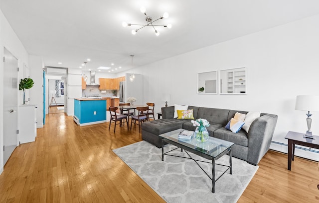 living area featuring recessed lighting, baseboard heating, light wood-type flooring, and a notable chandelier