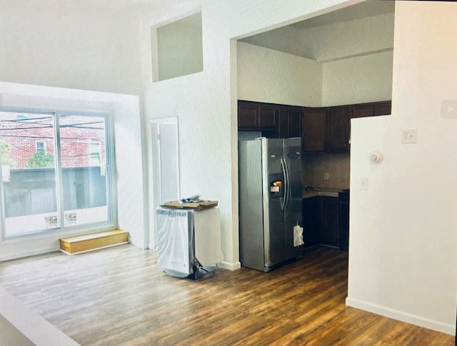 kitchen with dark brown cabinets, stainless steel fridge, and dark hardwood / wood-style flooring