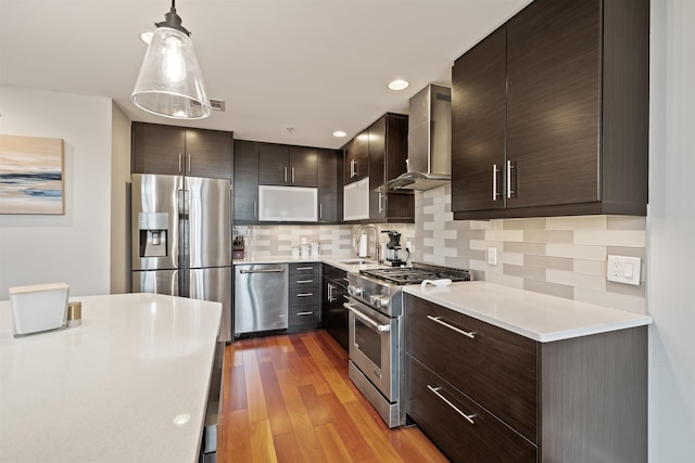 84 Willow Ave Unit 4B, Hoboken, NJ 07030 - kitchen featuring appliances with stainless steel finishes, wall chimney range hood, light countertops, and dark brown cabinetry