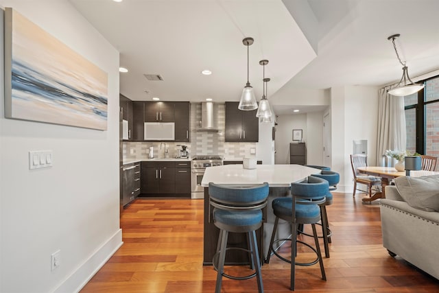 84 Willow Ave Unit 4B, Hoboken, NJ 07030 - kitchen with stainless steel range, wall chimney range hood, light countertops, backsplash, and recessed lighting