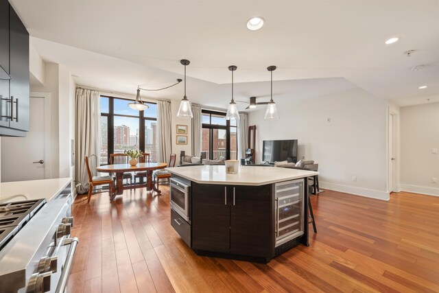 84 Willow Ave Unit 4B, Hoboken, NJ 07030 - kitchen with wine cooler, appliances with stainless steel finishes, hardwood / wood-style flooring, light countertops, and hanging light fixtures